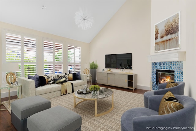 living room with high vaulted ceiling, wood finished floors, a tile fireplace, and baseboards