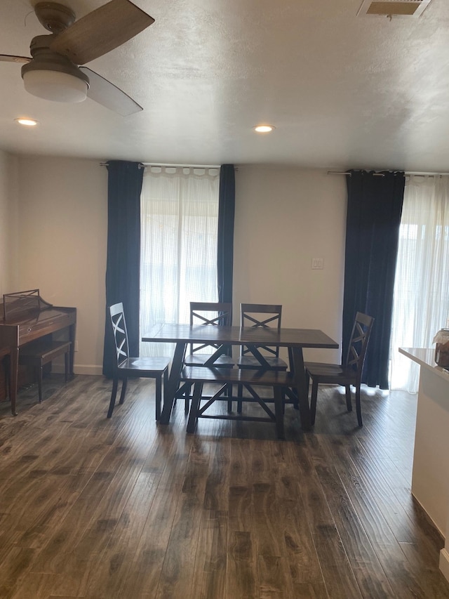 dining space with dark hardwood / wood-style flooring, ceiling fan, and a textured ceiling