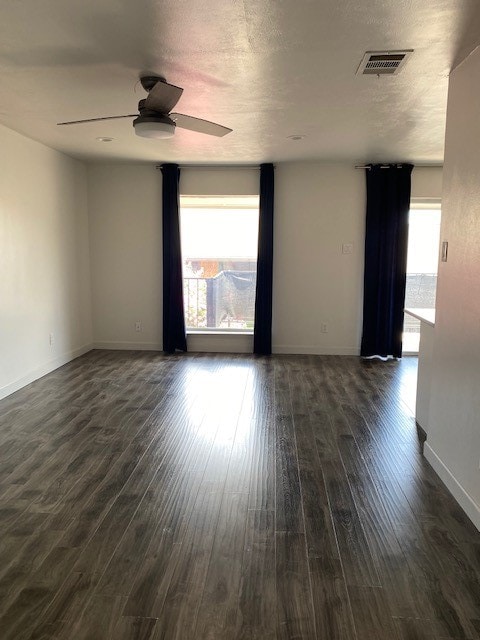 unfurnished room featuring dark hardwood / wood-style flooring, ceiling fan, and a textured ceiling