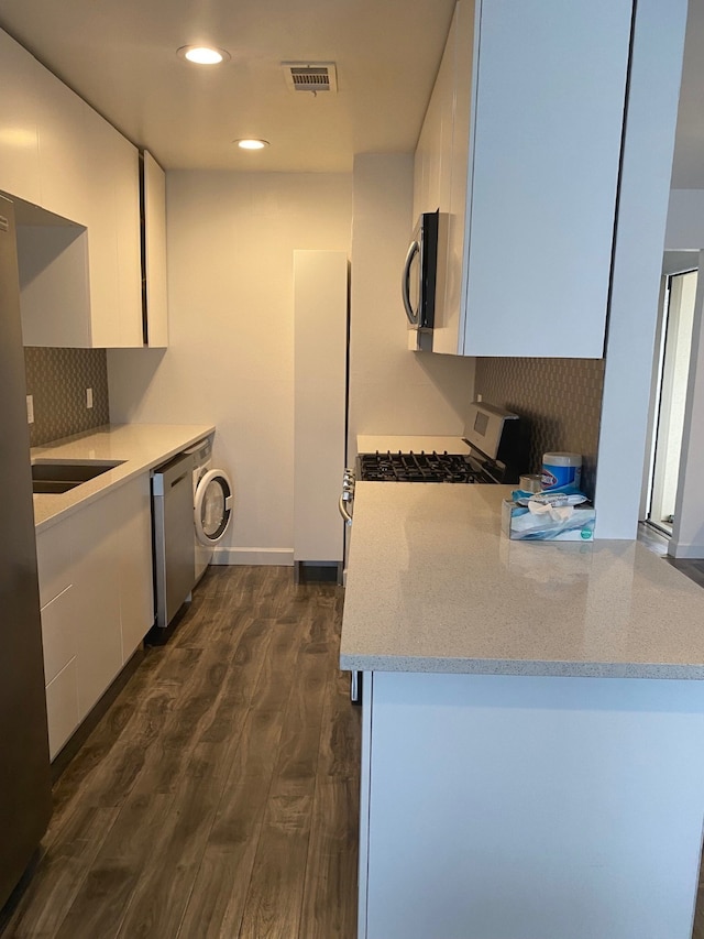 kitchen featuring white cabinetry, light stone countertops, dark hardwood / wood-style floors, and stainless steel appliances