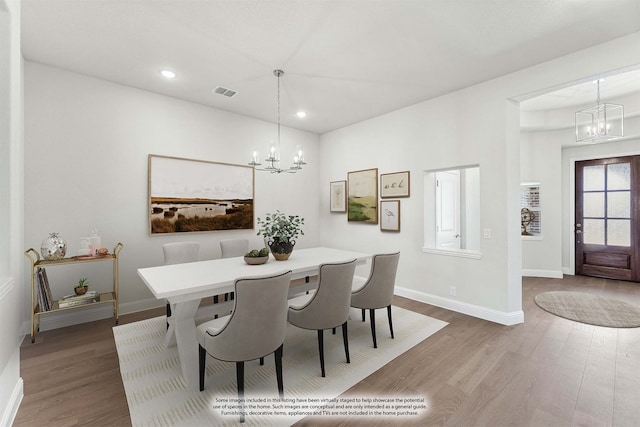 dining area with an inviting chandelier and hardwood / wood-style floors