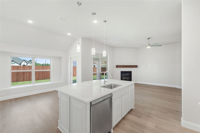 kitchen with a kitchen island with sink, light hardwood / wood-style flooring, sink, stainless steel dishwasher, and white cabinetry