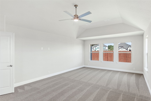 carpeted spare room with ceiling fan and vaulted ceiling