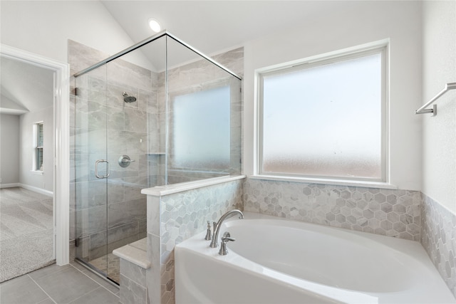 bathroom with plus walk in shower, vaulted ceiling, and a wealth of natural light