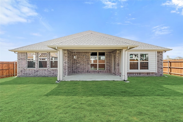 back of house featuring a patio area and a lawn