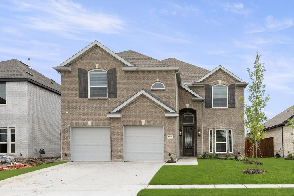 view of property with a garage and a front lawn