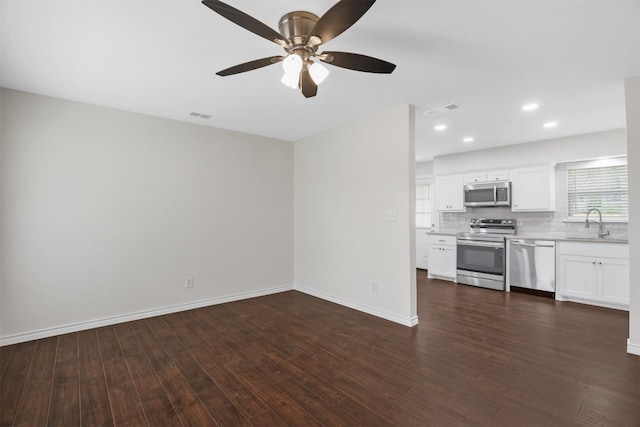 kitchen with ceiling fan, tasteful backsplash, white cabinetry, stainless steel appliances, and dark hardwood / wood-style floors