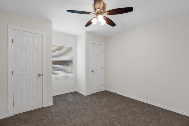 unfurnished bedroom with dark colored carpet and ceiling fan