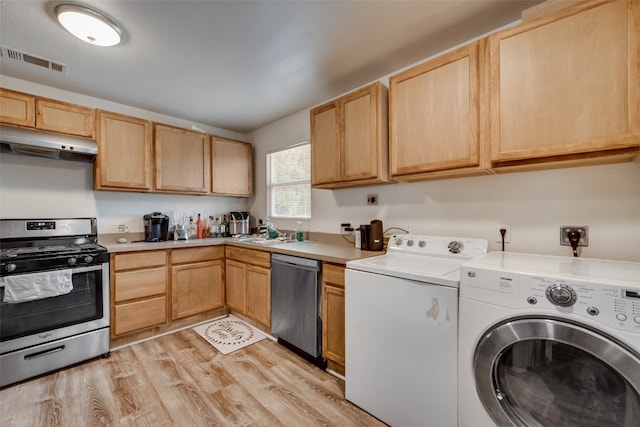 interior space with light brown cabinetry, light hardwood / wood-style flooring, stainless steel appliances, and washer and dryer