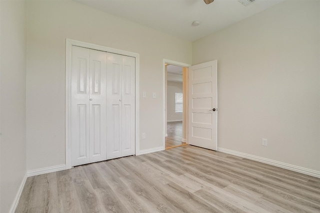 unfurnished bedroom featuring a closet, light hardwood / wood-style flooring, and ceiling fan