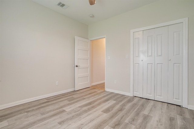 unfurnished bedroom featuring a closet, light hardwood / wood-style flooring, and ceiling fan