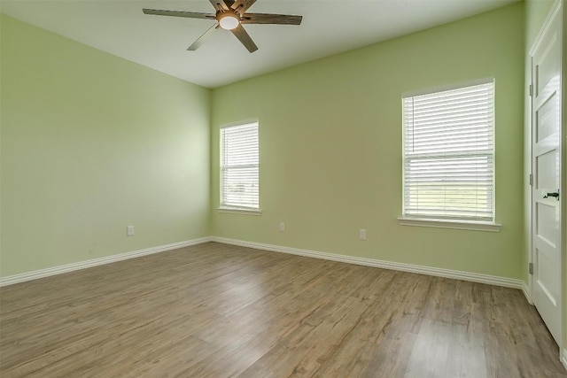 unfurnished room with a healthy amount of sunlight, wood-type flooring, and ceiling fan