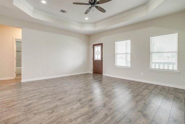 unfurnished room with a raised ceiling, ceiling fan, and hardwood / wood-style flooring