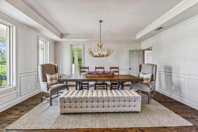 dining space featuring an inviting chandelier, a raised ceiling, a wealth of natural light, and dark wood-type flooring