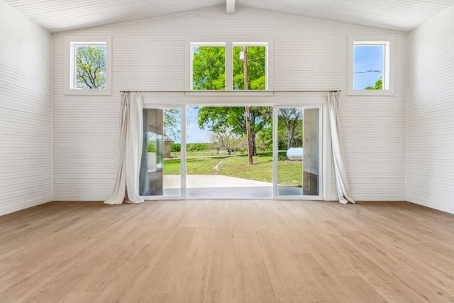 unfurnished room with light hardwood / wood-style floors and vaulted ceiling