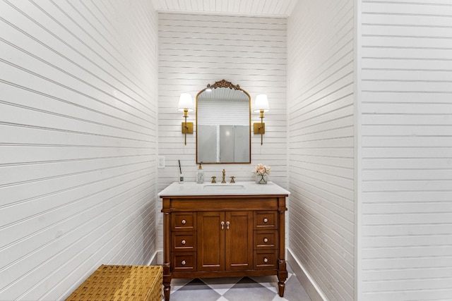 bathroom with tile floors, wooden walls, and large vanity