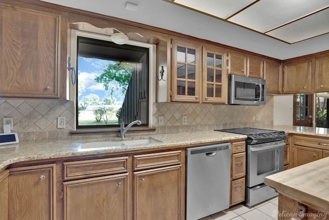 kitchen featuring sink, light tile patterned floors, appliances with stainless steel finishes, and tasteful backsplash