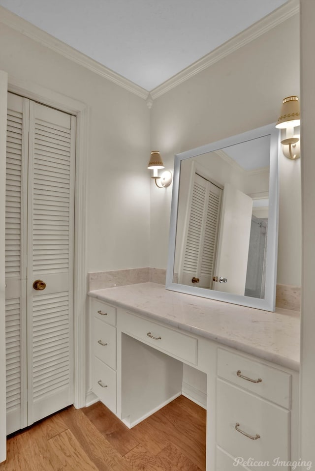 bathroom with vanity, ornamental molding, and wood-type flooring