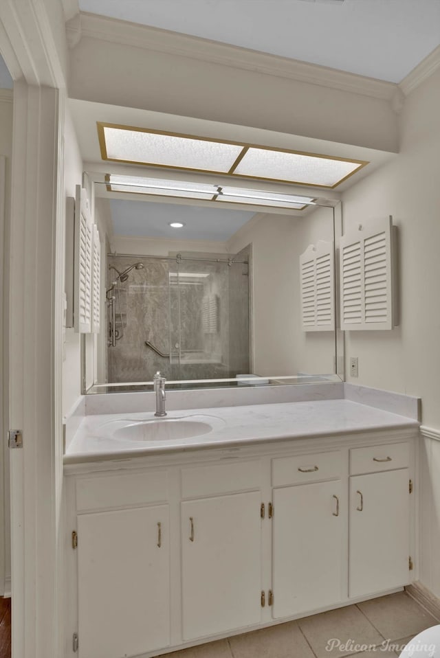 bathroom with tile patterned floors, a shower with door, crown molding, and vanity