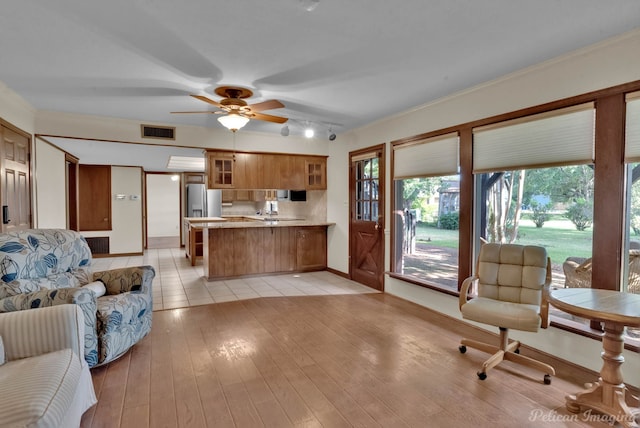 living room featuring crown molding, rail lighting, light tile patterned floors, and ceiling fan