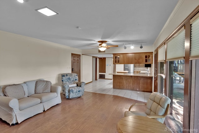 living room featuring crown molding, sink, rail lighting, ceiling fan, and light tile patterned flooring