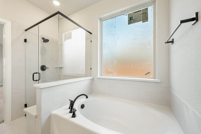 bathroom featuring independent shower and bath and a healthy amount of sunlight