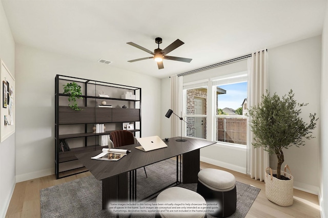 home office with light wood-type flooring and ceiling fan