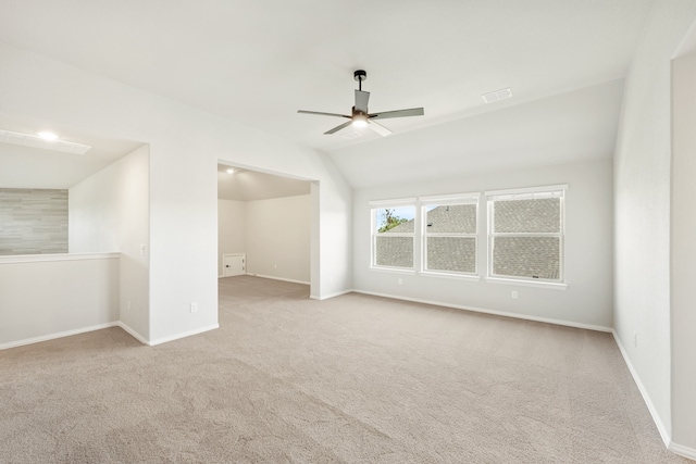 empty room featuring ceiling fan, lofted ceiling, and light colored carpet