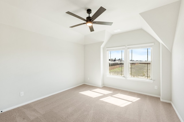 additional living space featuring ceiling fan, vaulted ceiling, and light colored carpet