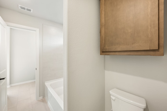 bathroom with toilet, tile patterned floors, and a bathing tub