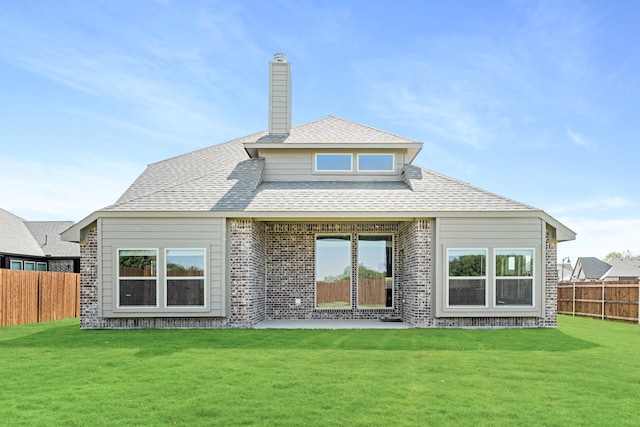 rear view of property featuring a lawn