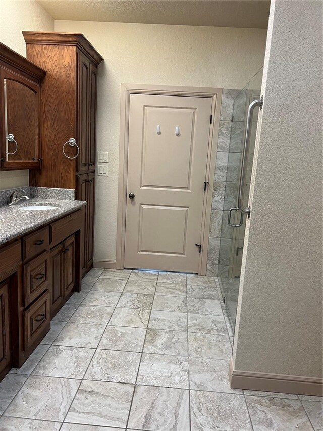 bathroom with walk in shower, tile patterned floors, and vanity