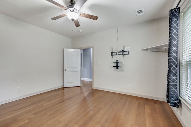 empty room featuring ceiling fan, light hardwood / wood-style flooring, and a wealth of natural light