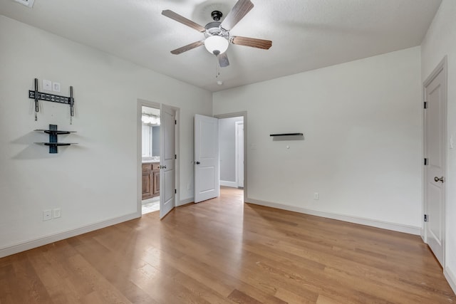 unfurnished bedroom with ensuite bath, ceiling fan, and light hardwood / wood-style flooring