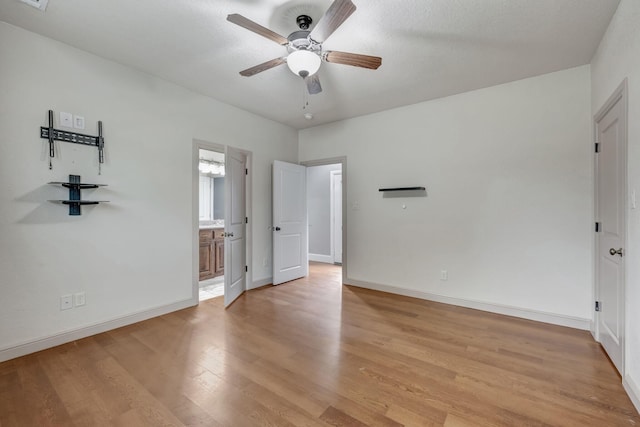 unfurnished bedroom featuring ceiling fan, light hardwood / wood-style floors, and ensuite bath