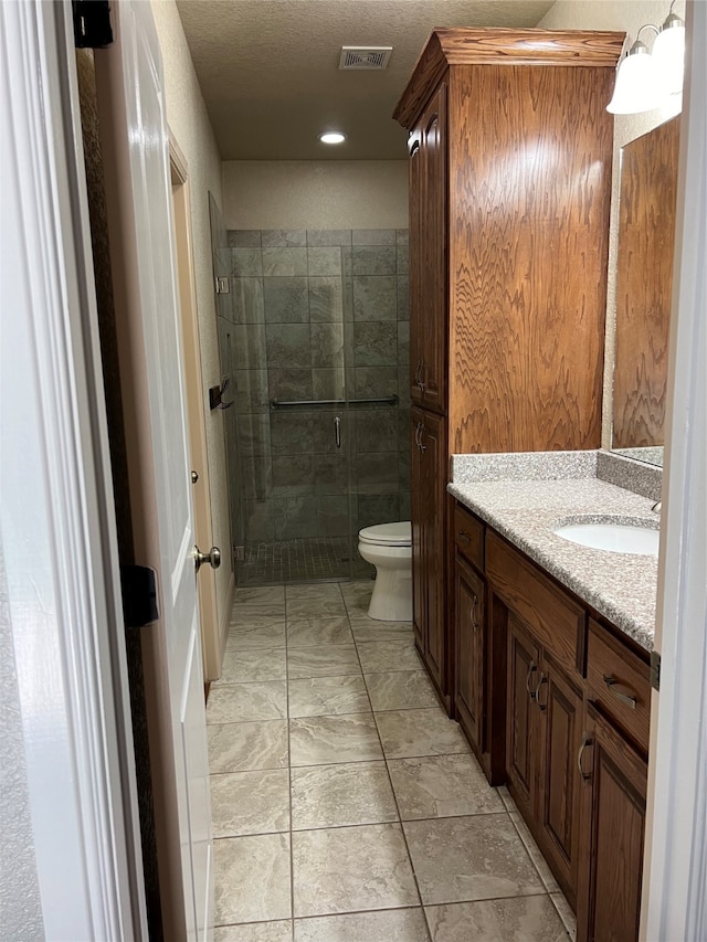 bathroom featuring vanity, toilet, tile patterned floors, and a shower with door