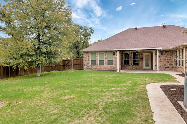 back of house featuring a patio area and a yard