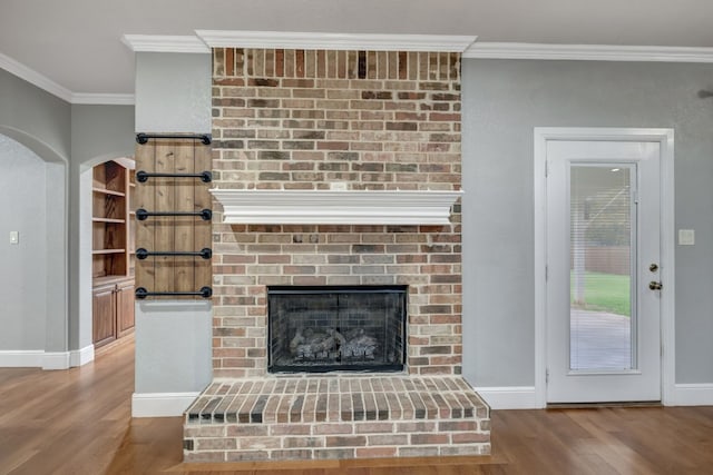 interior space with ornamental molding, a fireplace, and hardwood / wood-style flooring