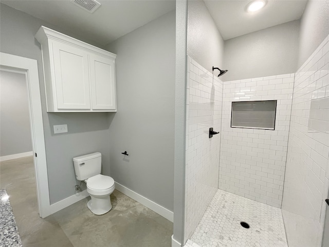 bathroom with toilet and a tile shower