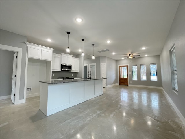 kitchen with white cabinetry, ceiling fan, hanging light fixtures, an island with sink, and sink