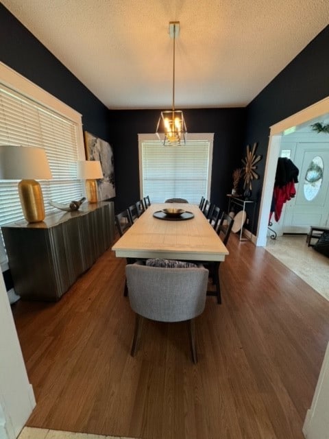 dining room with hardwood / wood-style floors and an inviting chandelier