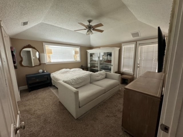 carpeted bedroom with vaulted ceiling, ceiling fan, and a textured ceiling