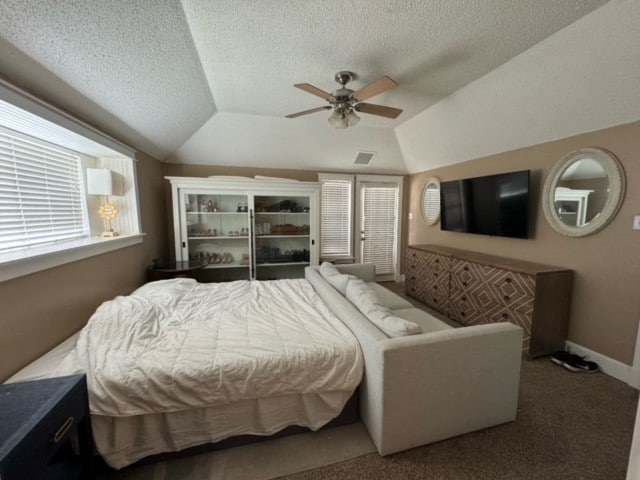 bedroom featuring dark colored carpet, a textured ceiling, ceiling fan, and vaulted ceiling