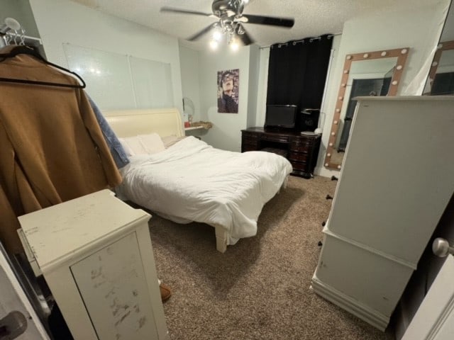 carpeted bedroom with a textured ceiling and ceiling fan