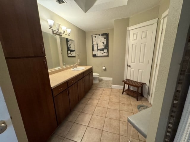 bathroom with vanity, toilet, and tile flooring