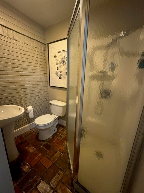 bathroom featuring walk in shower and toilet