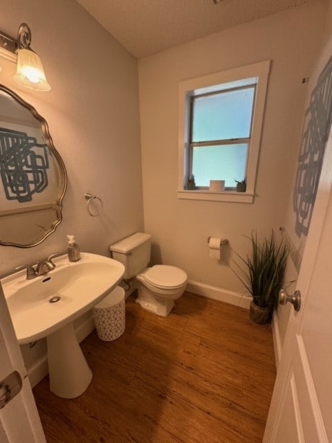 bathroom featuring a textured ceiling, toilet, and hardwood / wood-style floors