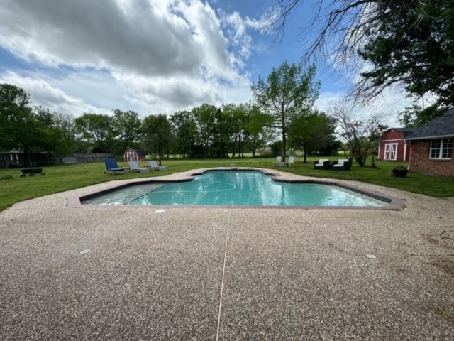 view of pool featuring a patio area and a yard