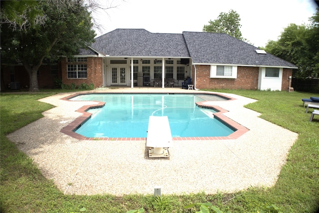 view of pool with a patio area, french doors, a yard, and a diving board