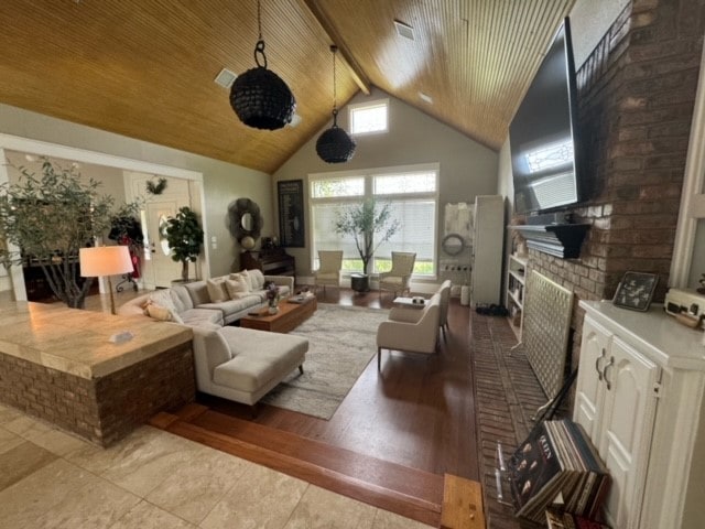 tiled living room featuring high vaulted ceiling, a fireplace, brick wall, beam ceiling, and wood ceiling